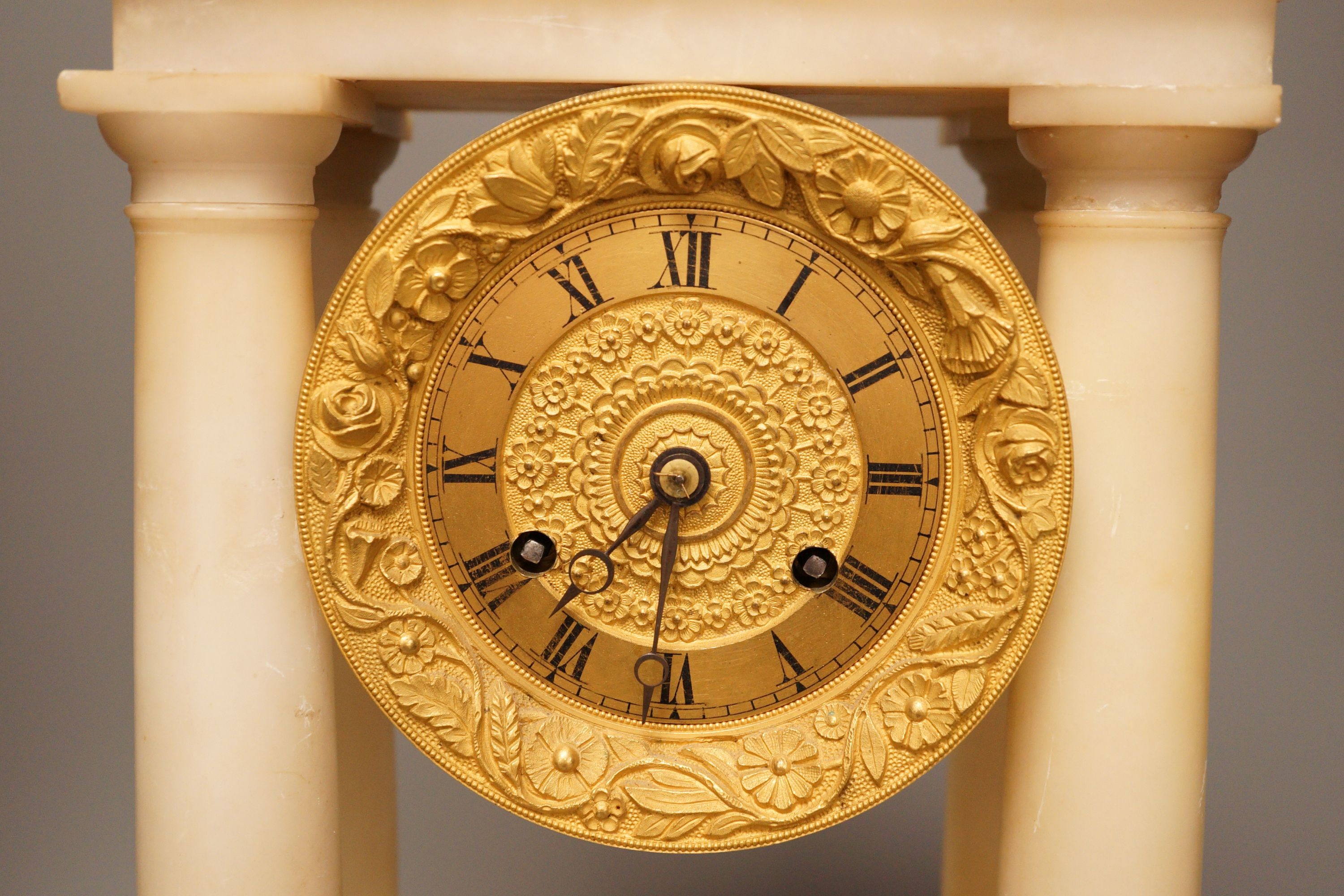 A 19th century alabaster portico clock with a gilt metal prowling lion decoration, 50cm tall